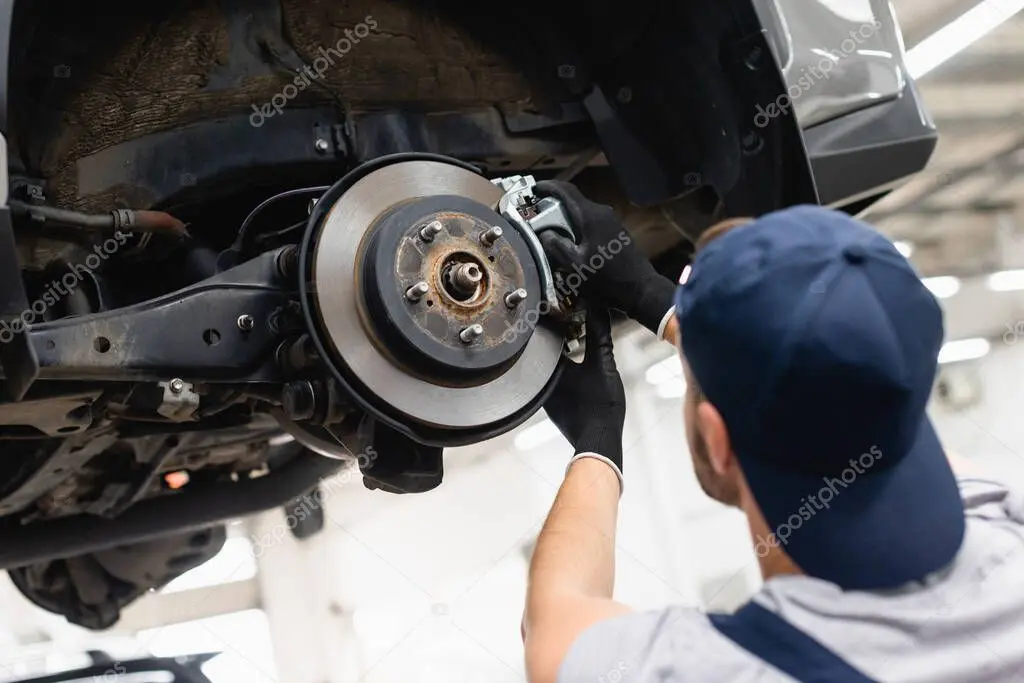 Mecánico revisando el sistema de frenos de un carro