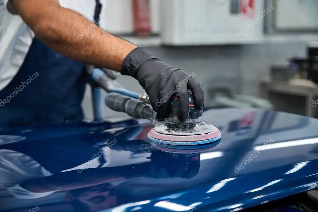 Técnico puliendo la pintura de un carro